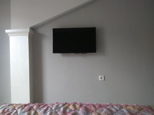 TV de pantalla plana en la pared de un dormitorio en Ivanoski Studios and Guest Rooms en Ohrid