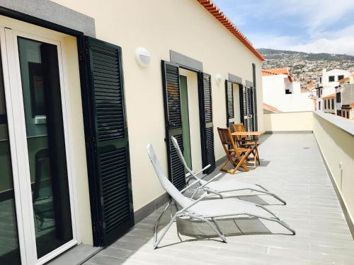 a pair of chairs on the balcony of a house at Apartamentos da Sé Catedral in Funchal