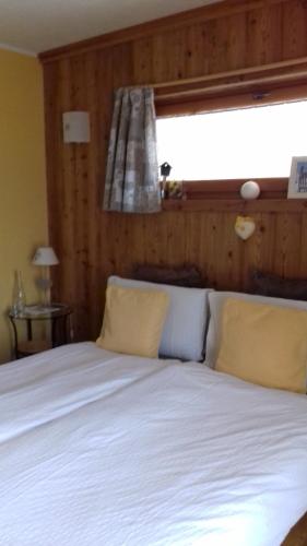 a bedroom with a white bed with a window at B&B Petit in Sauze dʼOulx