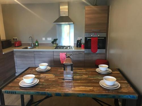 a kitchen with a wooden table with cups and saucers at Executive Brentwood Apartment in Brentwood