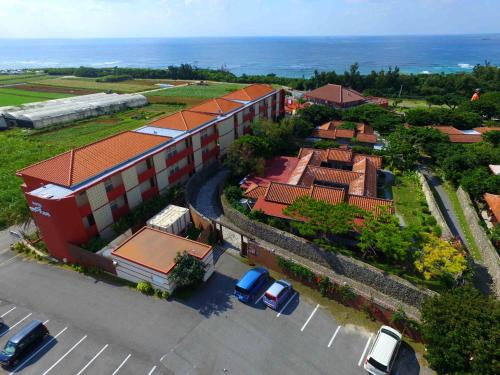 an overhead view of a building with cars in a parking lot at Hotel Murasakimura in Yomitan