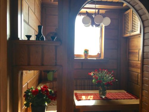 Cette chambre dispose d'une fenêtre et de 2 vases avec des fleurs sur une table. dans l'établissement Seven Heaven Warsaw/Siódme Niebo Warszawa, à Varsovie