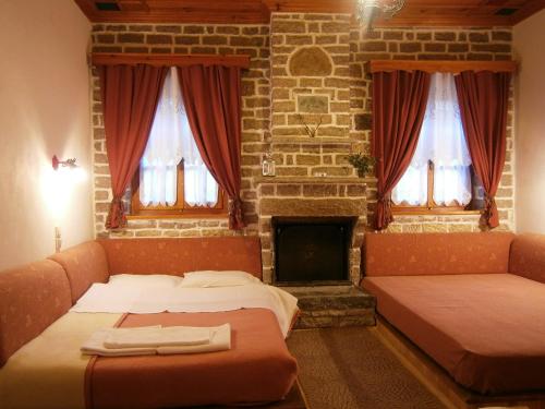 a living room with two beds and a fireplace at Filira in Vitsa