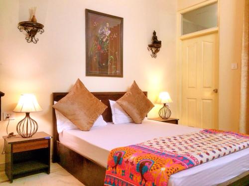 a bedroom with a bed and two lamps and a door at The Buddhayan Villa in Jaipur