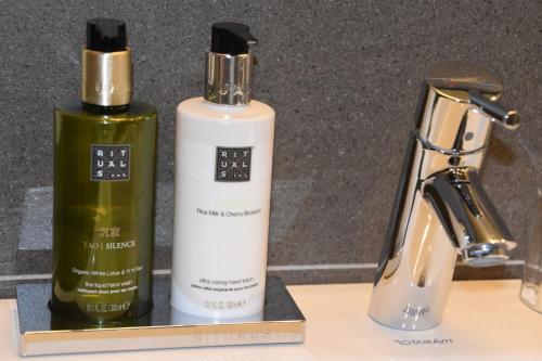 two bottles ofodorizers sitting on a counter next to a sink at RectoVersoVV in Sint-Pieters-Leeuw