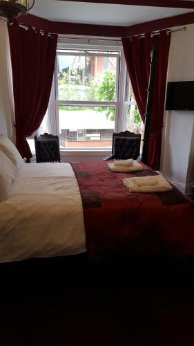 a bedroom with a large bed with a window at The Lodge Harrogate in Harrogate