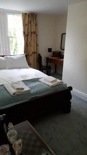 a bedroom with a bed with towels on it at The Lodge Harrogate in Harrogate