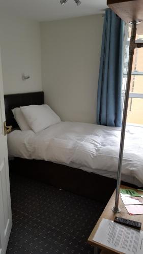 a bedroom with a bed and a desk with a lamp at The Lodge Harrogate in Harrogate