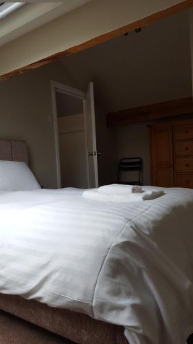 a large white bed in a bedroom with a door at The Lodge Harrogate in Harrogate