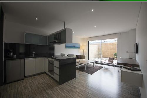a kitchen with black and white cabinets and a living room at Hotel Espacio 94 in Bogotá