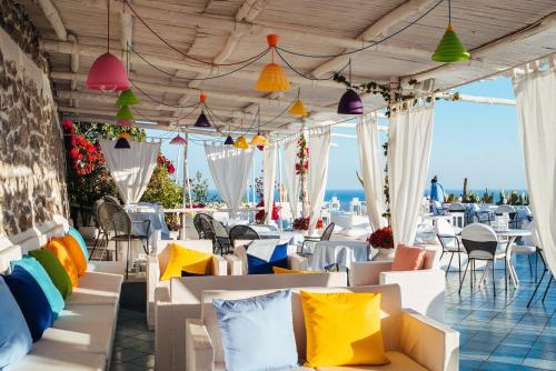 un restaurante con mesas, sillas y almohadas coloridas en Hotel Le Fioriere en Praiano