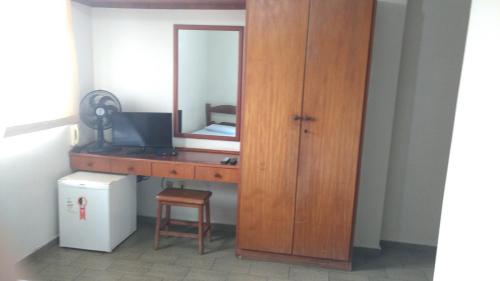 a wooden dresser with a mirror and a desk at Hotel Lund in Lagoa Santa