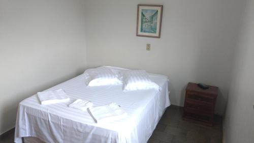 a white bed with two white towels on it at Hotel Lund in Lagoa Santa