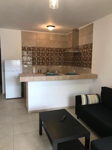 a living room with a couch and a kitchen at New cozy flat with pool in amazing place..! in Costa Del Silencio