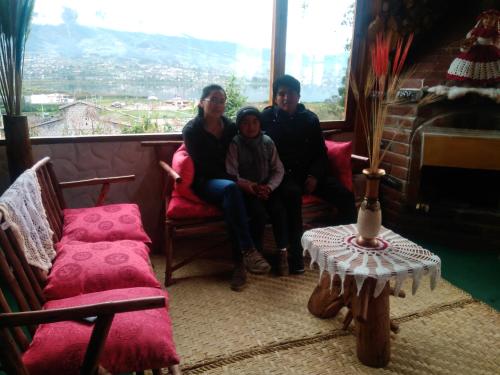 a group of three people sitting in a room with a window at Hospedaje Vertientes del Imbabura in Otavalo