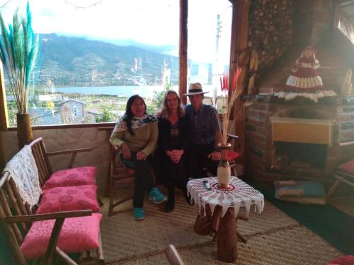 a group of three people sitting in a room with a window at Hospedaje Vertientes del Imbabura in Otavalo
