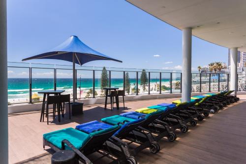 a row of chaise lounges on a balcony with the beach at Holiday Holiday Soul Apartments in Gold Coast