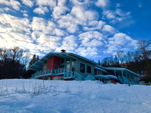 a house in the snow with a cloudy sky at Halcyon Heights B&B/Inn in Homer