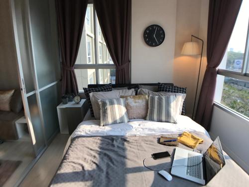 una camera da letto con un letto e un orologio a parete di Stay in Style at Oasis a Chiang Mai
