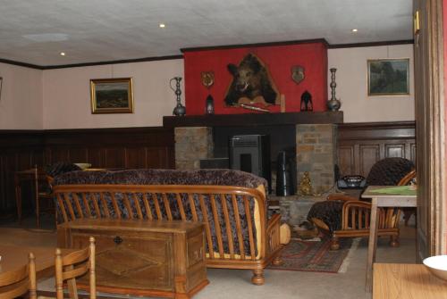 布永的住宿－樂凱迪歐爾酒店，客厅设有壁炉、桌子和椅子