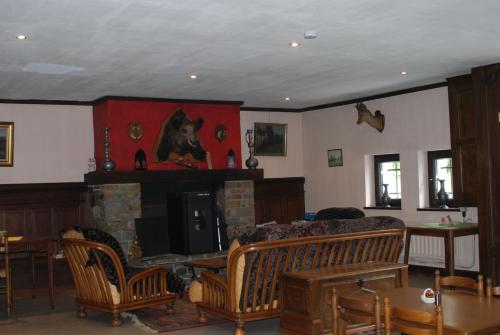 a living room with a fireplace and a couch and chairs at Le K d'Or in Bouillon