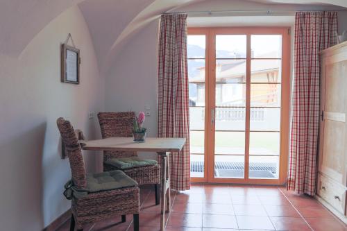 a dining room with a table and chairs and a window at Marhof Pustertal in Anras
