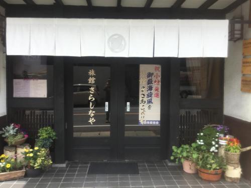 a front door of a restaurant with potted plants at Ryokan Sarashinaya in Kiso
