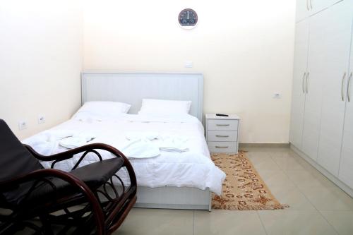 a white bedroom with a bed and a chair at Holiday Home Ali in Piqeras