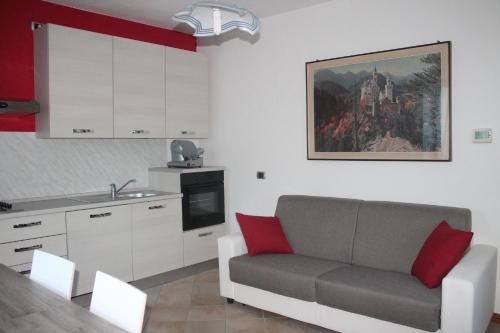 a living room with a couch and a kitchen at La casa delle grigne in Mandello del Lario