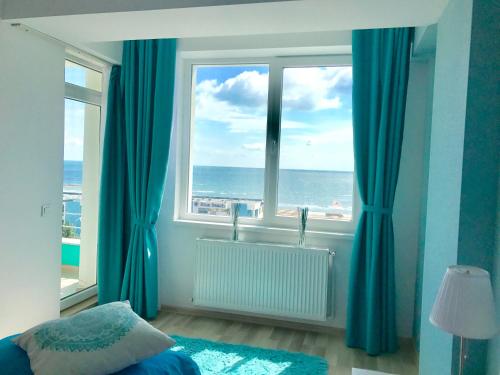 a bedroom with a window with a view of the ocean at Summerland Sea View in Mamaia