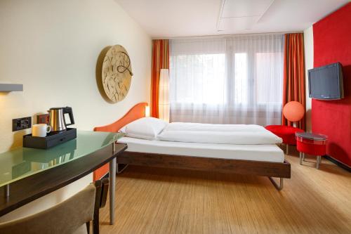 Postel nebo postele na pokoji v ubytování Ramada by Wyndham Baden Hotel du Parc