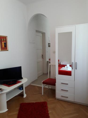 sala de estar con escritorio y armario blanco en Apartments Eldin, en Dubrovnik