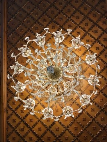 a chandelier hanging from the ceiling of a room at KERCULLA Resort in Gjirokastër