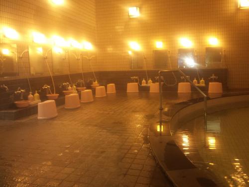 a room with a pool of water with toilets and lights at Mount View Hotel in Kamikawa