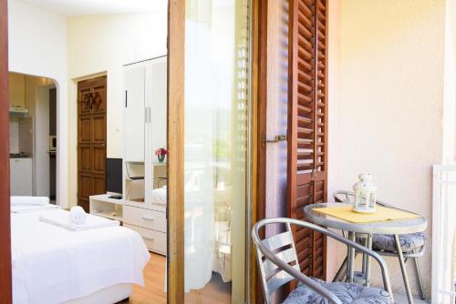 Cette chambre comprend un lit, une table et un miroir. dans l'établissement Apartment ANA Podstrana, à Podstrana