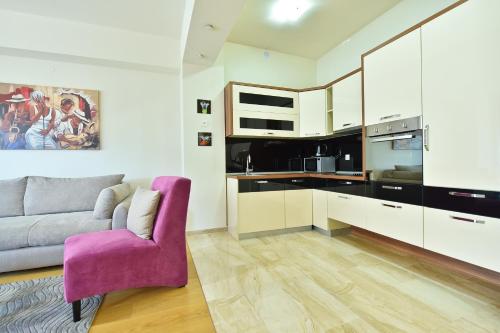 a living room with a couch and a purple chair at Lux Apartments Sunrior in Budva