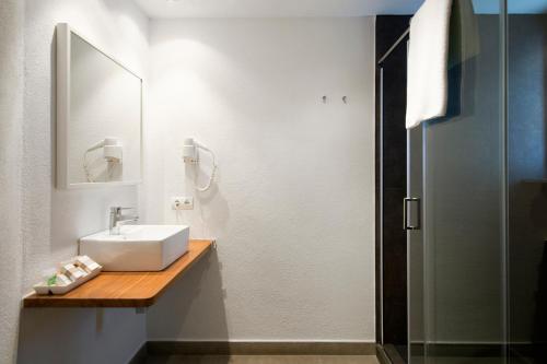 a bathroom with a sink and a mirror and a shower at Horta d'en Rahola - Adults Only in Cadaqués