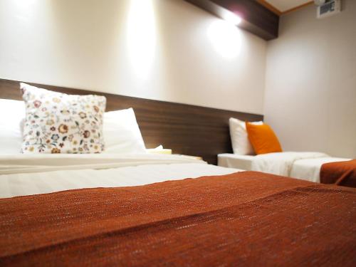 a hotel room with two beds and a couch at Hotel Park Hill Myeongdong in Seoul