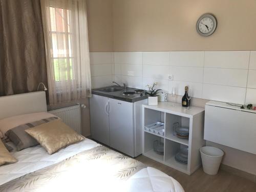 a small kitchen with a bed and a sink at Linden Garden Apartment in Postojna