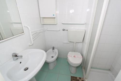 リド・ディ・ポンポーザにあるConchiglia apartmentsの白いバスルーム(洗面台、トイレ付)