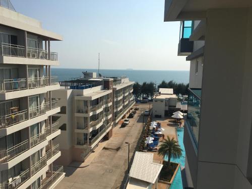 an aerial view of a street with buildings and the ocean at Grand Blue Condominium by Nuttaya in Klaeng
