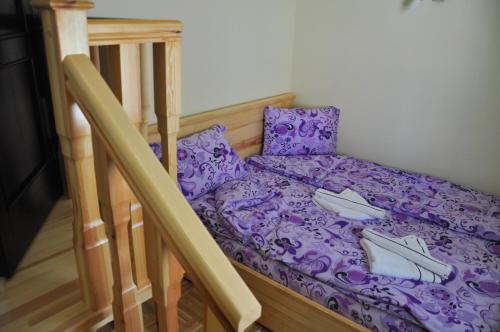 Una cama en una habitación con sábanas y almohadas moradas. en Apartmani Vidic, en Zlatibor