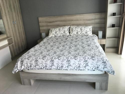 a bedroom with a large bed with a wooden headboard at Grand Blue Condominium by Nuttaya in Klaeng
