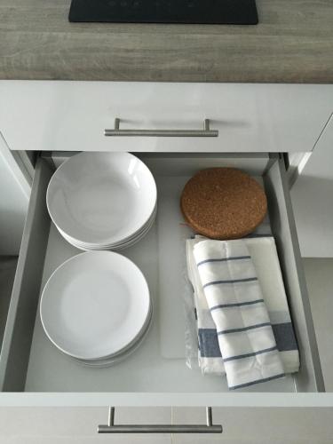 un armadietto bianco con piatti e asciugamani di Grand Blue Condominium by Nuttaya a Klaeng