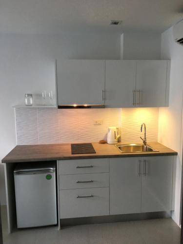 a kitchen with white cabinets and a sink at Grand Blue Condominium by Nuttaya in Klaeng