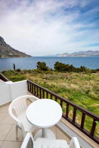 a white table and chairs on a balcony overlooking the water at Avra Studios in Masouri