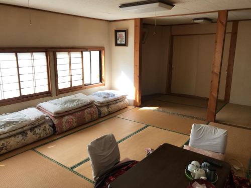 um quarto com duas camas e uma mesa em Niko Ryokan em Aizuwakamatsu