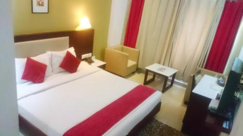 a hotel room with a bed with red pillows at Hotel Hills Park Pathanamthitta in Pathanāmthitta