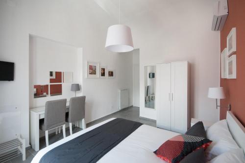a bedroom with a bed and a desk in it at B&B Dietro il Teatro in Palermo