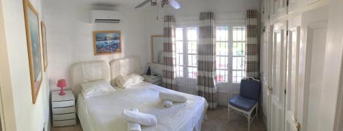 エステポナにあるSunny Garden Apartmentのベッドルーム(白いベッド1台、青い椅子付)